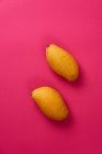 Плоский плоский фрукт манго на рожевому барвистому картонному фоні — стокове фото