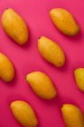 Плоские фрукты манго в розовом цветном картонном фоне — стоковое фото