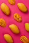 Piatto laici mango frutta tagliata a metà cubi in rosa sfondo cartone colorato — Foto stock