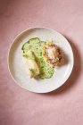 Cremesauce zu leckerem Fischgericht mit Kräutern auf rosa Hintergrund im Restaurant — Stockfoto