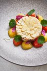De cima tartare de peixe delicioso servido com amêndoas e tomates cereja frescos no prato no restaurante — Fotografia de Stock