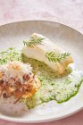 Salsa alla panna per gustoso piatto di pesce con erbe su sfondo rosa nel ristorante — Foto stock