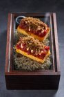 Dolce pan di Spagna con marmellata di bacche e riccioli di cioccolato posti sulla scatola con muschio secco — Foto stock
