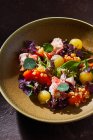 Vue du dessus du bol avec une délicieuse salade de crabe aux légumes frais et aux herbes placées sur une table brune — Photo de stock