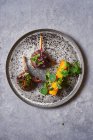 Vue du dessus de médaillons de viande savoureux avec des herbes sur plaque sur table en marbre gris — Photo de stock