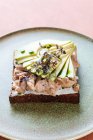 Do acima mencionado sanduíche de atum saboroso com partes de abacate fresco colocado na chapa na cafetaria — Fotografia de Stock