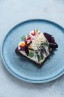 Overhead saboroso peixe e ovo sanduíche com ervas frescas e queijo desfiado colocado na placa na cafetaria — Fotografia de Stock