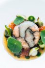 Зверху смачна железована риба зі свіжою ікрою та овочами, поданими на білому тлі — стокове фото