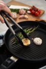 Grill pan with rosemary and garlic in kitchen — Stock Photo