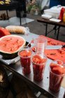 De cima de copos plásticos de partes de melancia frescas na mesa metálica no mercado — Fotografia de Stock