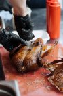 From above of crop male in gloves cooking fried chicken on wooden table in market stall — Stock Photo