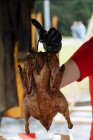 De arriba de la cosecha el macho en los guantes que cuecen el pollo frito a la mesa de madera en el puesto del mercado - foto de stock