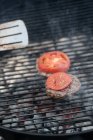 De cima de costeletas de cozinha com fumaça na grelha com hambúrguer e tomates na banca de mercado — Fotografia de Stock