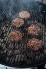 From above of cooking cutlet with smoke on grill in market stall — Stock Photo
