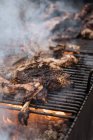 From above of cooking chicken with smoke on grill in market stall — Stock Photo