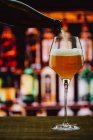 Bière en verre à vin avec mousse en verre sur comptoir en bois en bar sur fond flou — Photo de stock
