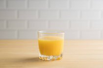 Jus d'orange en verre sur la table — Photo de stock
