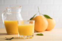 Succo d'arancia in vetro sul tavolo — Foto stock