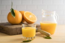 Jugo de naranja en vaso sobre la mesa - foto de stock