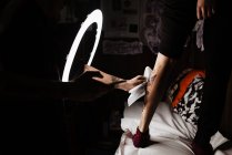 Unerkannter Tätowierer mit Smartphone fotografiert Tätowierung am Bein eines Kunden für Portfolio in zeitgenössischem Studio — Stockfoto