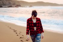 Жінка ходить на мокрій піску на пляжі — стокове фото
