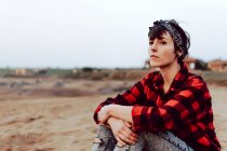 Nachdenkliche Hipster-Frau sitzt am Sandstrand — Stockfoto