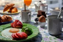 Hausgemachtes gesundes Frühstück mit Eiern, Avocado, Erdbeeren, Blaubeeren, Biskuit, Croissants, Toast, Tee, Kaffee und Orangensaft — Stockfoto