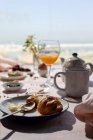 Hausgemachtes komplettes Brunchfrühstück im Sonnenlicht mit Croissants, Tee, Kaffee und Orangensaft — Stockfoto