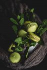 Macarons verdes caseiros verdes com hortelã no fundo escuro. Comida escura . — Fotografia de Stock