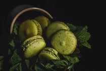 Macarons verdes caseiros verdes com hortelã no fundo escuro. Comida escura . — Fotografia de Stock