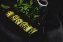 Macarons verdi fatti in casa verde con menta su sfondo scuro. Cibo scuro . — Foto stock