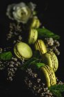 Macarons verdi fatti in casa verde con menta su sfondo scuro. Cibo scuro . — Foto stock