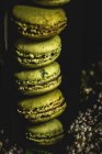 Homemade green macarons green with mint on dark background. Dark food. — Stock Photo