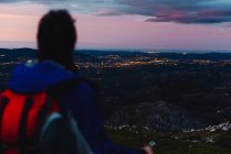 Повертаючись до туризму з рюкзаком і палицею, оглядаючись удалечінь і милуючись мальовничими краєвидами під час прогулянки по гірській дорозі під хмарним небом в Іспанії. — стокове фото