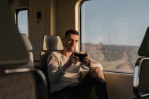Junger männlicher Fahrgast benutzt Smartphone in U-Bahn — Stockfoto