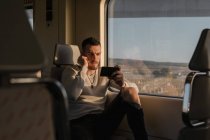 Pasajero varón joven usando smartphone en metro - foto de stock
