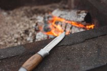 Hunting knife next to fireplace — Stock Photo