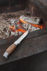 Hunting knife next to fireplace — Stock Photo