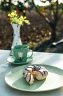 Komposition aus aromatischem Heißgetränk und leckeren Donuts auf dem Tisch — Stockfoto