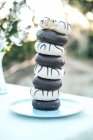 Yummy donuts with icing and chocolate ganache stacked on plate — Stock Photo