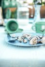 Tazza vuota su piattino e piatto di briciole di pasta frolla con cucchiaio sul tavolo — Foto stock