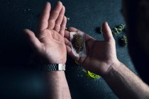 Неузнаваемый мужчина делает марихуану дома — стоковое фото