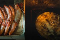 De acima mencionado peixe fresco em linha na bandeja pronta para fritar no óleo na cozinha — Fotografia de Stock