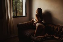 Спокуслива молода жінка в нижній білизні лежить на дивані — стокове фото