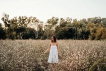 Нежная леди, стоящая в цветущем поле — стоковое фото