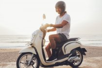 Motociclista alegre na praia arenosa — Fotografia de Stock