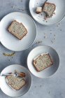 Pedaços de bolo de limão e sementes de papoila servidos em pratos brancos — Fotografia de Stock