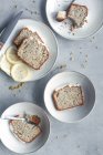 Vista dall'alto di aromatici gustosi dolci di limone e papavero fatti in casa tagliati su porzioni e serviti su piatti bianchi sul tavolo di marmo — Foto stock