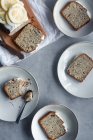 Trozos de pastel de semillas de limón y amapola servidos en platos blancos - foto de stock