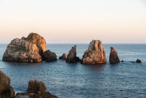 Paysage pittoresque de rochers dans la mer paisible et skyline au crépuscule sur la Costa Brava — Photo de stock